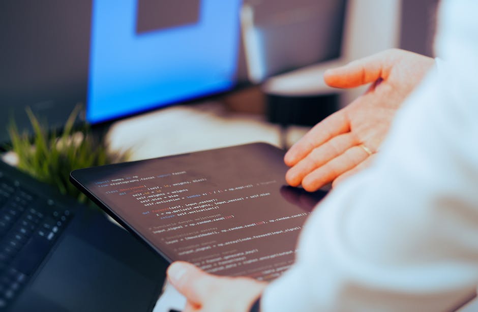Software developer analyzing code on a tablet in a modern office workspace