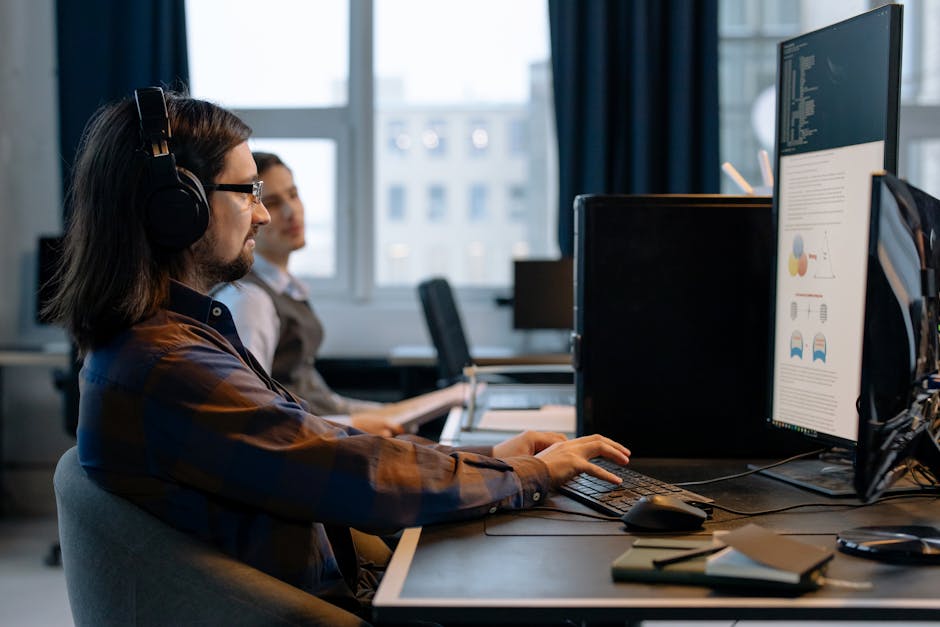 Two programmers working together with focus on coding in a modern, tech-savvy office environment